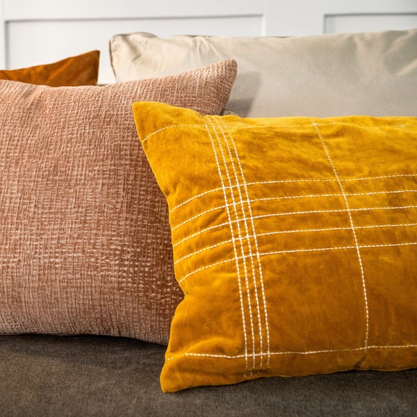 Dekorative Kissen mit verschiedenen Texturen und Mustern auf einer Couch