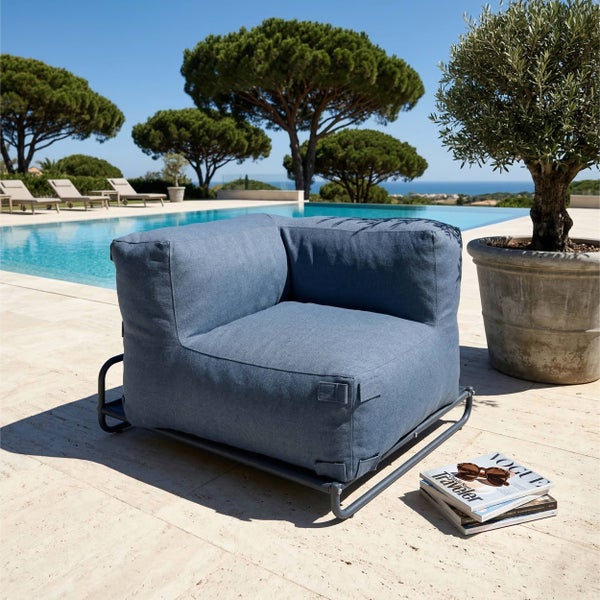 Moderner Outdoor-Loungesessel mit blauem Stoffbezug und Metallgestell auf einer hellen Terrasse am Pool.