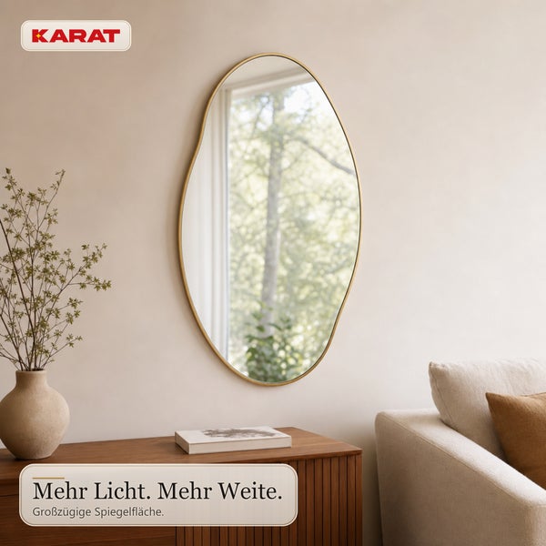 Wandspiegel mit unregelmäßig geformtem Rahmen an einer Wand über einem Sideboard, Karat Logo.