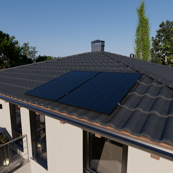Zwei auf einem dunklen Ziegeldach montierte Solarmodule an einem Wohnhaus mit weißer Fassade und Fenstern.