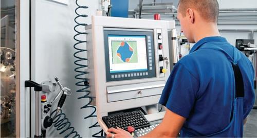 Mann bedient computergesteuerte numerische Steuerung zur Maschinensteuerung