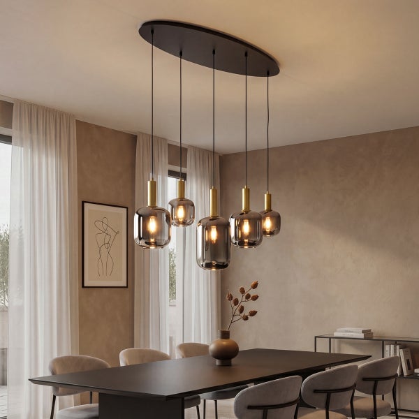 Moderne Hängeleuchte mit fünf Glaspendeln in einem Esszimmer mit dunklem Esstisch und Stühlen