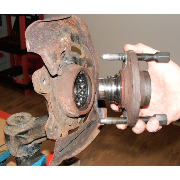 Werkzeug zum Auspressen eines Traggelenks an einem Radlagergehäuse, befestigt in einem Schraubstock