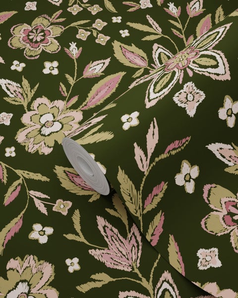 Vliestapete mit floralem Muster in Pink und Beige auf grünem Untergrund, Ansicht einer teilweise abgerollten Tapetenrolle.