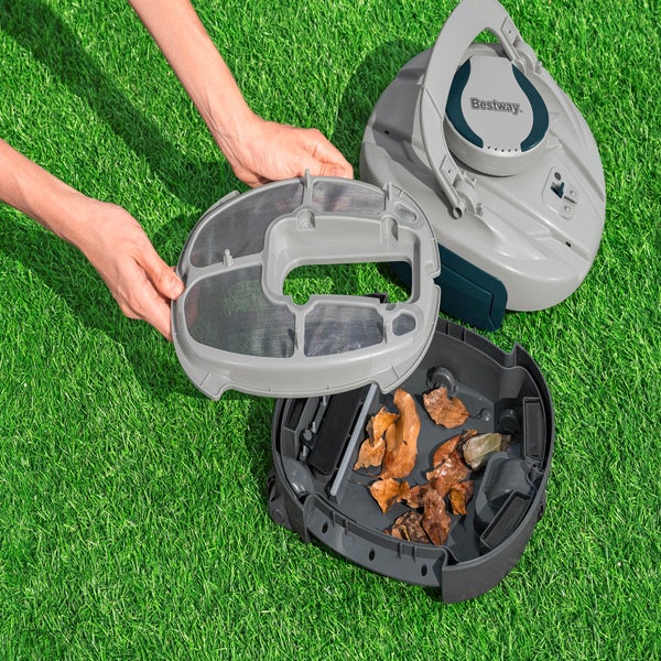 Person leert Behälter eines Poolreinigungsroboters auf Rasen.