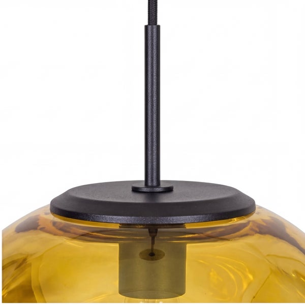 Detailaufnahme einer Pendelleuchte mit schwarzer Metallaufhängung und bernsteinfarbenem Glasschirm.