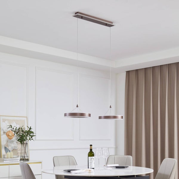 Moderne zweiflammige LED-Pendelleuchte in Ringform über einem runden Esstisch in einem hellen Esszimmer.