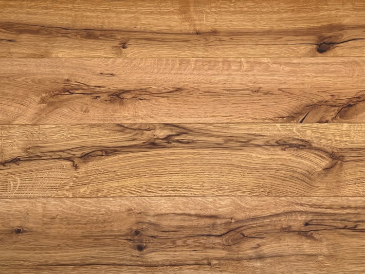Detailansicht von Bodenbelag in Holzoptik mit ausgeprägter Maserung und Ästen.