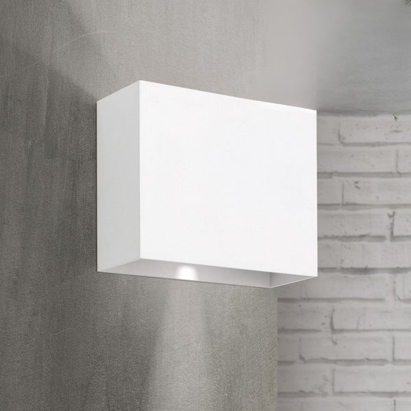 Rechteckige Wandleuchte in Weiß an einer grauen Wand neben einer Ziegelwand, modernes Design mit Lichteffekt nach unten.