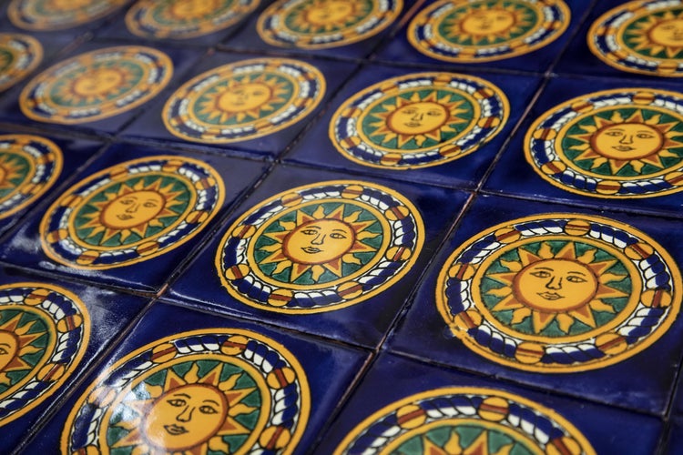 Mehrere quadratische Fliesen mit einem Sonnenmotiv