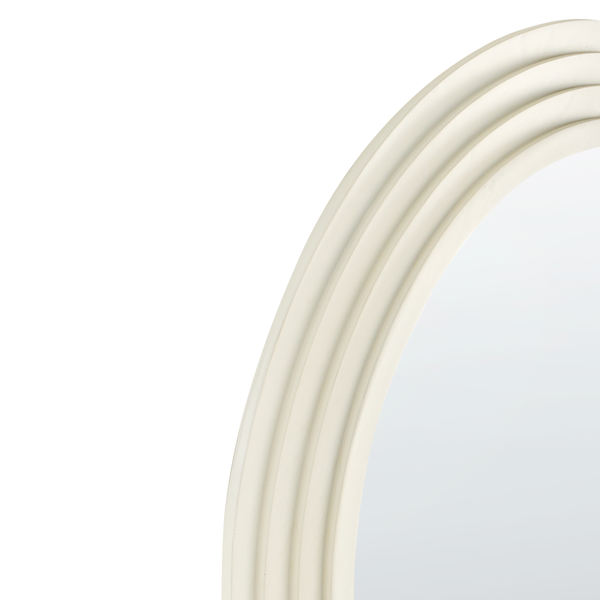 Detail eines runden Spiegels mit cremefarbenem Rahmen und gestuftem Profil.
