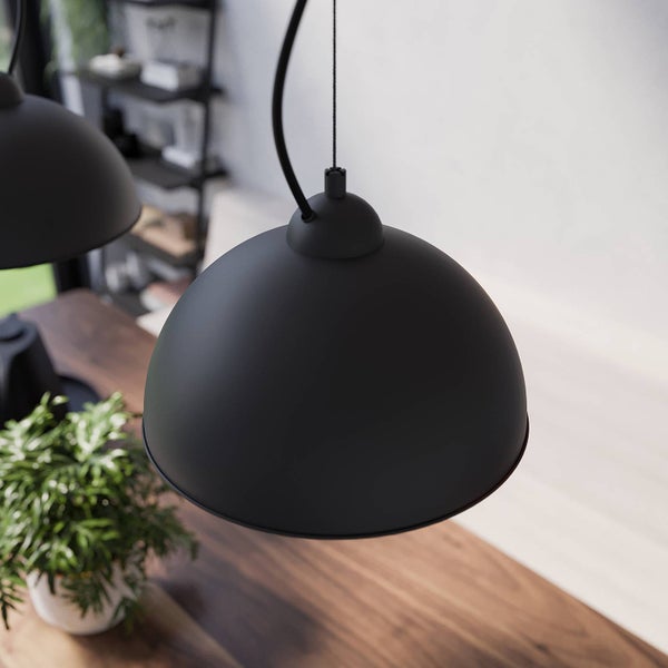 Schwarze Hängelampe über einem Holztisch