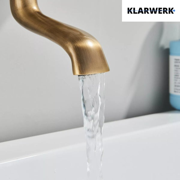 Ein gebogener Wasserhahn aus Metall mit fließendem Wasser über einem Waschbecken und Klarwerk Logo.