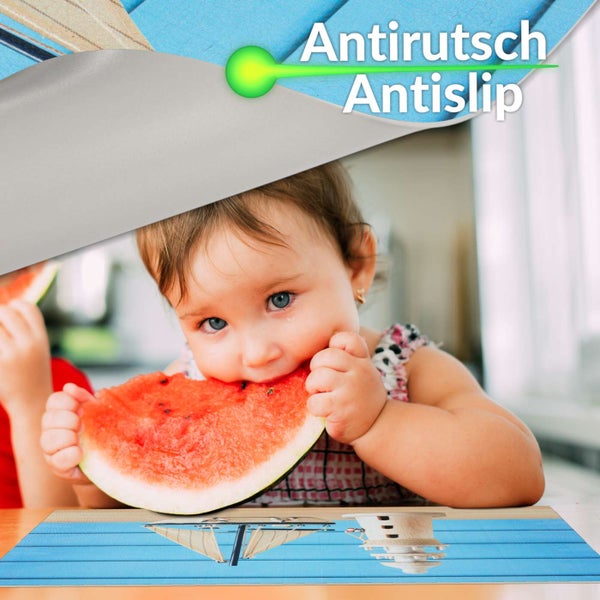 Kind isst Wassermelone auf einem rutschfesten Platzset mit maritimen Motiven von Segelboot und Leuchtturm.