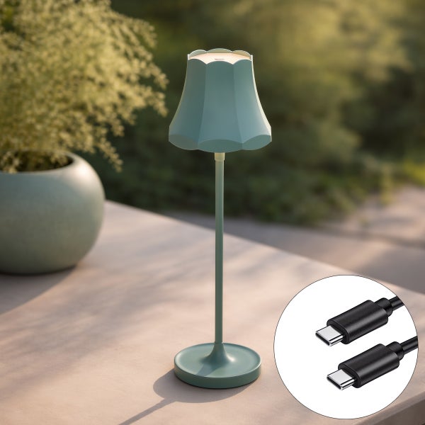 Akkubetriebene, mintgrüne LED-Tischleuchte mit gewelltem Schirm und USB-C-Anschluss auf einem Tisch im Außenbereich.