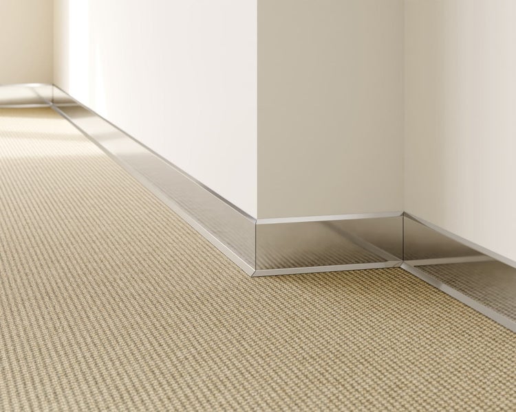 Sockelleiste aus Metall an einer Wand über einem Teppichboden