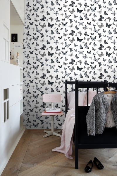 Kinderzimmer mit Bett und Wandtapete mit Schmetterlingsmuster