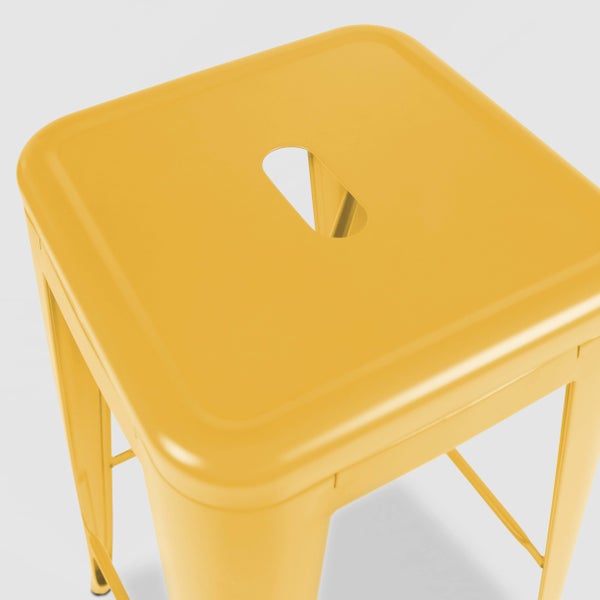 Gelber Metallhocker im Industriedesign mit quadratischer Sitzfläche und Griffloch.