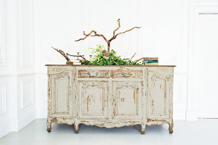 Buffetschrank im Landhausstil mit floraler Dekoration und Büchern