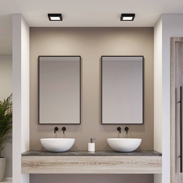 Modernes Badezimmer mit Holz-Doppelwaschtisch, zwei weißen Aufsatzbecken, zwei Spiegeln mit schwarzen Rahmen und schwarzen Wandarmaturen.