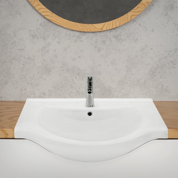 Weißes Waschbecken mit Armatur und Spiegel im Badezimmer