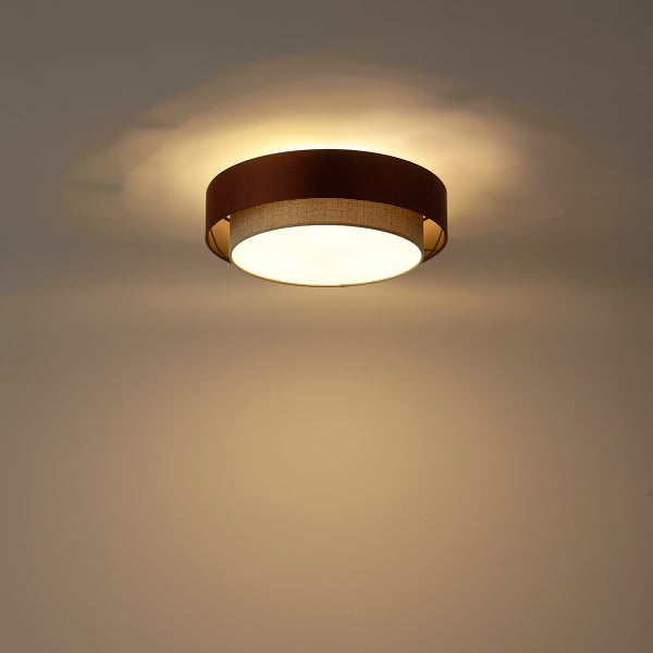 Moderne runde Deckenleuchte mit zweilagigem Textilschirm aus Stoff, warm leuchtend an der Decke.