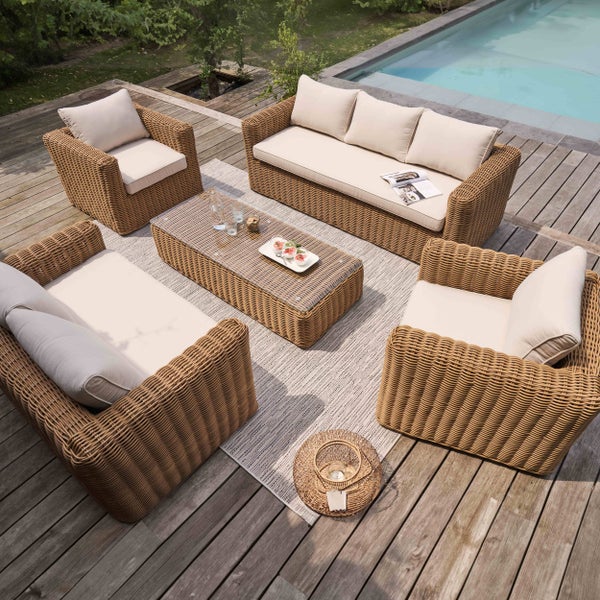 Garten-Lounge-Set aus Geflecht mit zwei Sofas, zwei Sesseln und einem Couchtisch auf einer Holzterrasse am Pool.