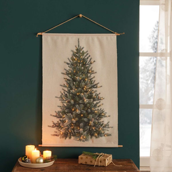 Dekorative Szene mit einem Wandteppich mit Weihnachtsbaum, Kerzen und einem Geschenk