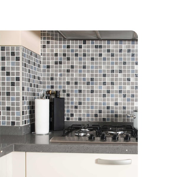 Moderne Küche mit grauem Mosaikfliesenspiegel, Gaskochfeld auf dunkler Arbeitsplatte und weißen Unterschränken.