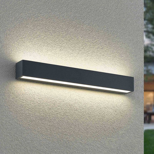 Moderne schwarze LED-Außenwandleuchte in rechteckiger Balkenform mit Lichtaustritt nach oben und unten an einer Wand.