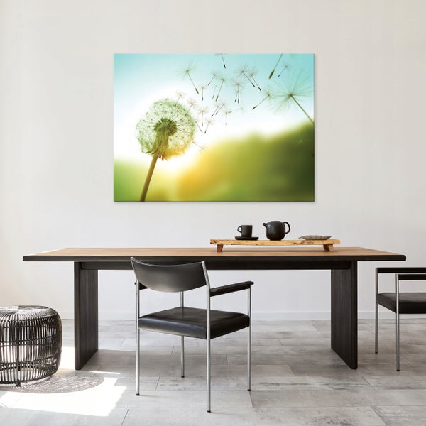 Modernes Esszimmer mit großem Leinwandbild Pusteblume, Holztisch und schwarzen Designerstühlen in heller Atmosphäre.