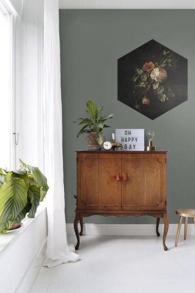 Zimmeransicht mit Holzschrank, Dekorationen und sechseckigem Bild an der Wand