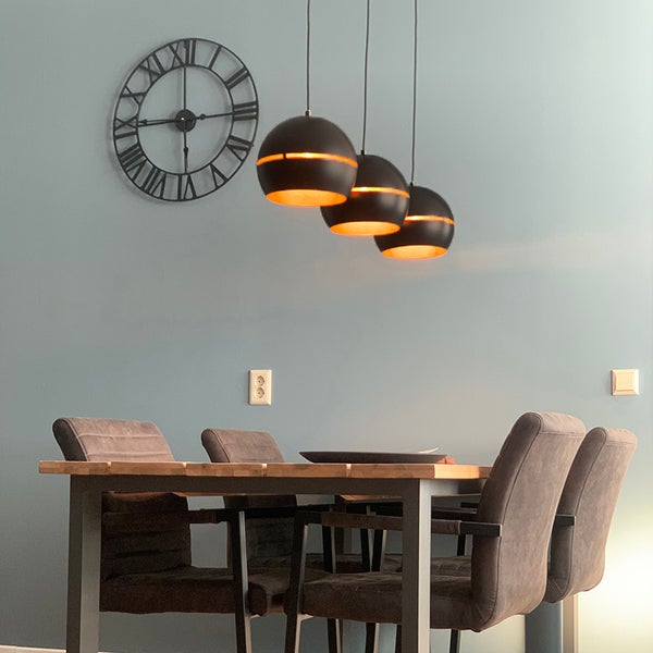 Esszimmer mit Esstisch, Stühlen, Pendelleuchten und Wanduhr
