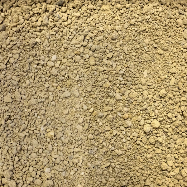 Nahaufnahme von beigem Kalksand oder Splitt als Baumaterial.