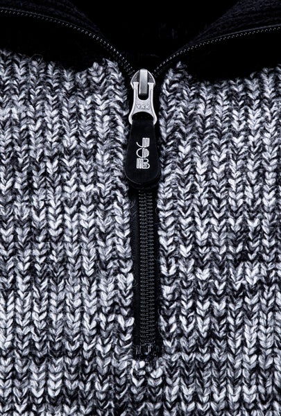 Nahaufnahme eines Reißverschlusses an einer Strickjacke mit FHB Logo am Schieber.