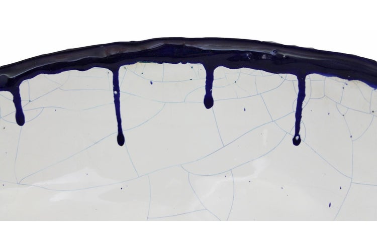 Detailaufnahme eines Keramiktellers mit Craquelé-Glasur und Dekor