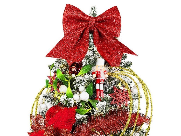 Weihnachtsbaumspitze mit roter Schleife, Nussknacker, Beeren und Tannenzweigen als Dekoration für den Christbaum.