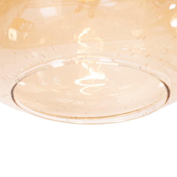 Nahaufnahme einer gelblichen Glaslampe mit eingeschalteter Glühbirne