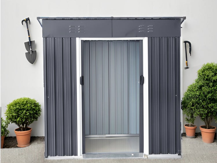 Modernes Metall-Gerätehaus in Anthrazit mit Schiebetür, Wellblechwänden und Lüftungsschlitzen vor einer weißen Wand.