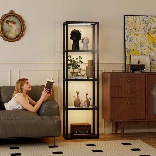 Hohes Regal mit integrierter Beleuchtung in einem hellen, modern eingerichteten Wohnzimmer neben einem Sofa und einer Kommode aus Holz.