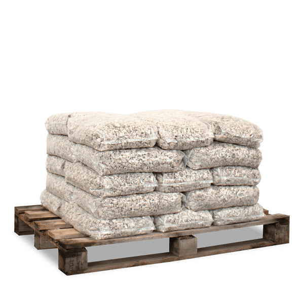 Mehrere transparente Säcke mit hellem Ziersplitt gestapelt auf einer Holzpalette für den Gartenbau.