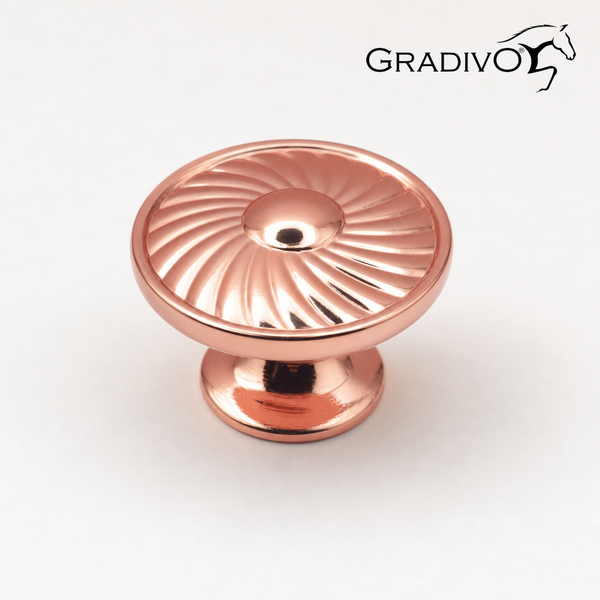 Runder kupferfarbener Möbelknopf mit Spiralmuster und Gradivo Logo.
