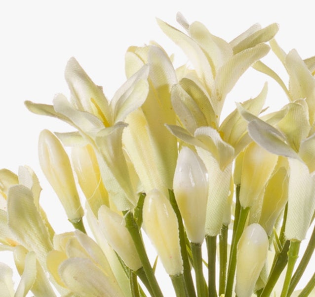 Künstliche cremefarbene Blüten und Knospen aus Textil an grünen Stielen.