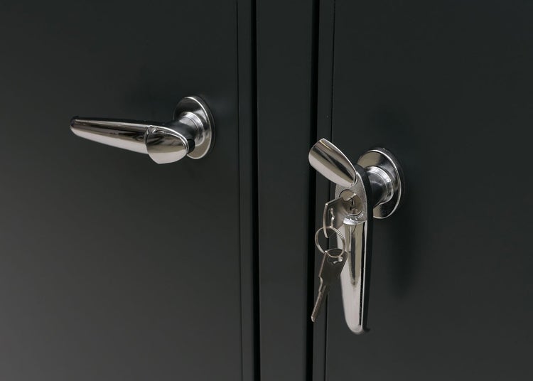 Detailaufnahme eines Schranks mit Griff und Schloss inklusive Schlüssel