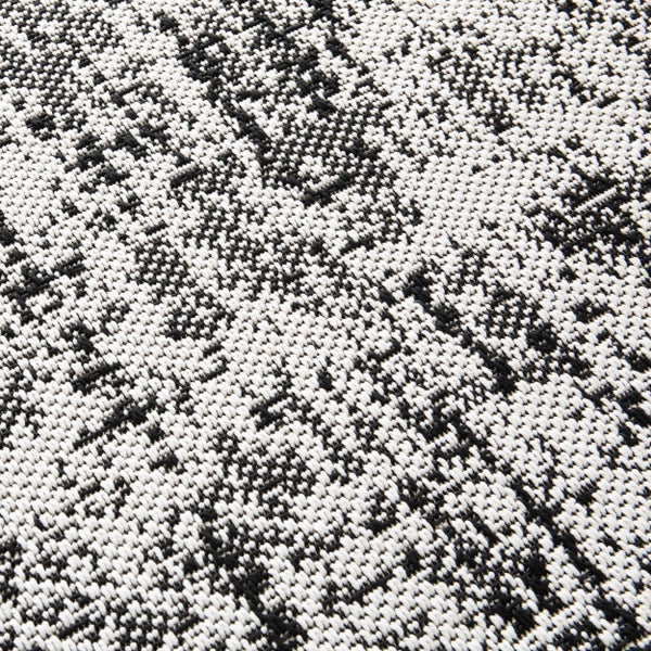 Nahaufnahme eines gewebten Teppichs mit schwarz-weißem Melange-Muster.