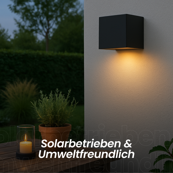 Moderne, schwarze Wandleuchte für den Außenbereich spendet warmes Licht an einer Hauswand