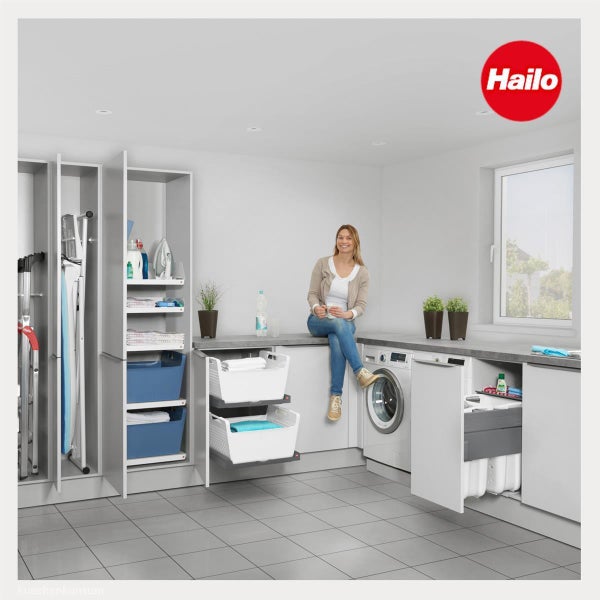 Moderner heller Hauswirtschaftsraum mit organisierten Hailo Einbauschränken Waschmaschine ausziehbaren Wäschekörben und Hailo Logo.