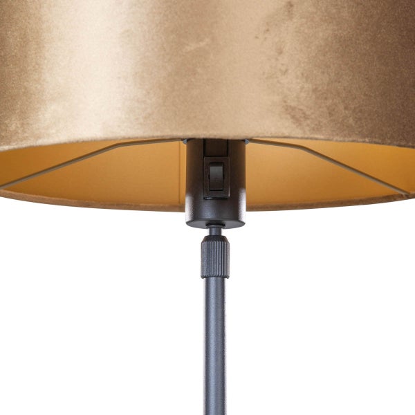 Nahaufnahme einer Leuchte mit bronzefarbenem Stoffschirm, Lampenfassung und integriertem Kippschalter am schwarzen Metallstab.