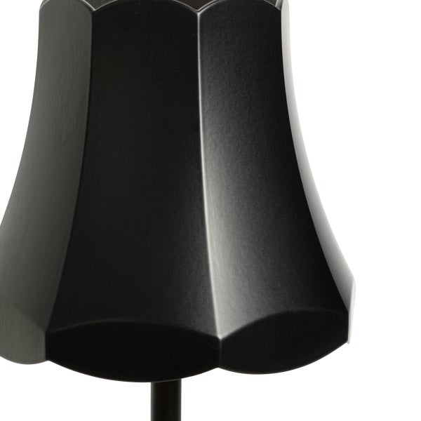 Nahaufnahme eines schwarzen facettierten Lampenschirms mit geschwungenem Rand.
