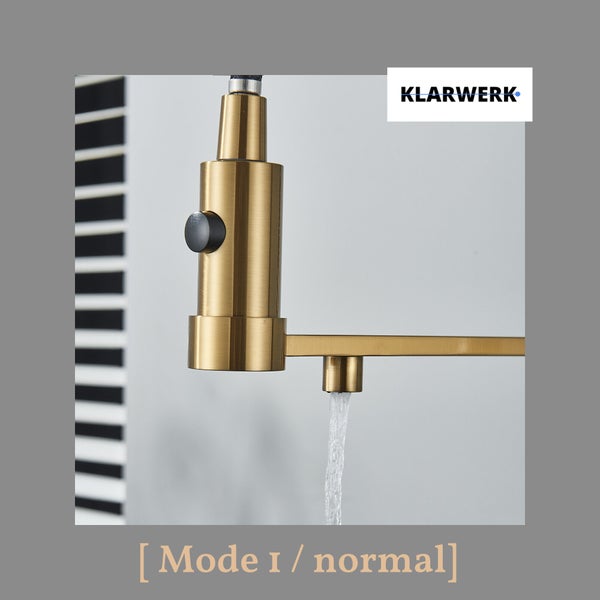 Klarwerk Logo. Goldfarbene Küchenarmatur mit Wasserstrahl im Normalmodus und ausziehbarer Brause mit schwarzem Knopf.